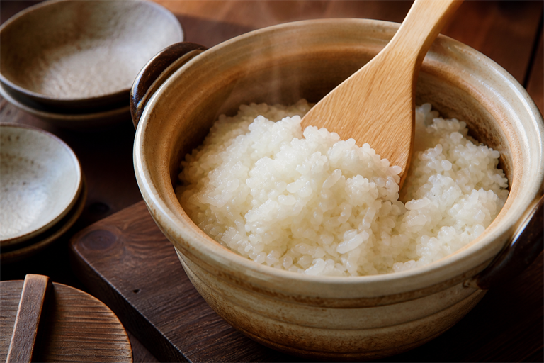 Step 5: a wooden shamoji cutting and folding glossy freshly cooked japanese short-grain 
