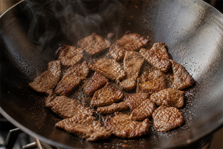 Step 5: slices of beef seared in a single layer against the dark patina of a hot carbon